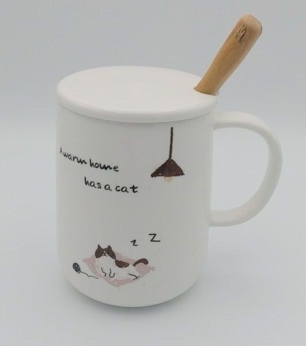 Tasse blanche avec dessin chat et sa cuillère en bois.